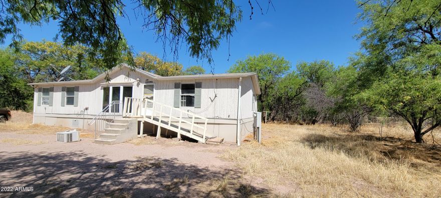 This is a beautiful piece of property. It is located on the Babocomari River riparian area. The mesquite trees are some of the largest I have seen. They are gorgeous. The native trees and shrubs are very thick. There is a barn, several outbuildings, a private well and it is also fenced and cross fenced. The manufactured home is not affixed currently. Do to the condition, it is being sold as land value only. This is a completely AS IS sale.