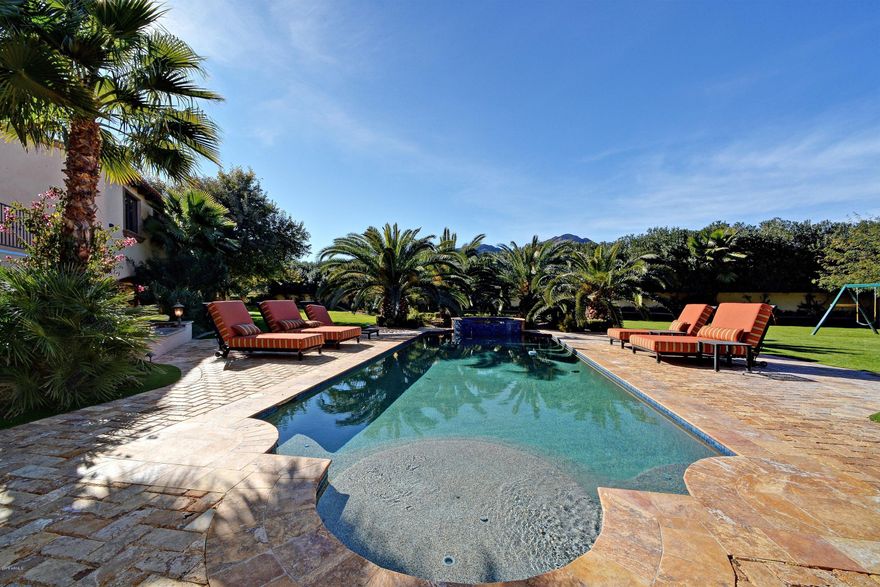 Fabulous 2009 gated estate in the heart of Paradise Valley w/ an incredibly lush green resort style backyard & beautiful Camelback Mtn. views! This gorgeous estate boasts a main house w/ 4 bdrms (all ensuite) & an office w/ stunning wood coffered ceiling details + a fully finished basement w/ a huge media rm & game rm. + a separate kids bonus room in the secondary wing of the home.  Additionally the separate guest house has a full kitchen & family rm + separate master bathrm (also ensuite) & a 1 car garage! Rich warm appointments & beautiful ''old world'' finishes make a huge statement of warm  beauty in this fabulous Tuscan estate!  Enjoy every day living & entertaining in true AZ luxury style w/ family & friends when the wall of telescoping glass have retracted into the walls & your outside sunny living areas become part of your indoor living spaces!  Split master floor plan & private master covered patios make it truly fabulous for the owners of the home to enjoy total privacy from the active rooms of this estate. Enjoy your own private balcony in the secondary wing overlooking this tropical lushly landscaped huge backyard featuring gorgeous mature canary palm trees lining the resort style pool area!