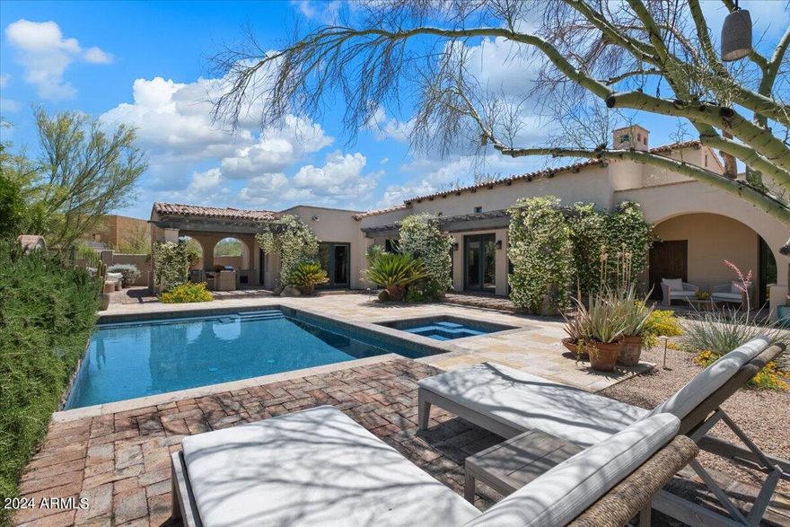 Welcome to your dream home in the exclusive, guard-gated community of Whisper Rock in North Scottsdale. This stunning Spanish-style residence offers 4,740 square feet of luxurious living space, featuring four spacious bedrooms, four and a half baths, and a dedicated office. Enjoy the elegance of arched doorways, multiple fireplaces, including a magnificent canterra stone fireplace in the great room, and a 720-bottle wine cellar for the connoisseur. The separate guest house off the front courtyard provides additional privacy and convenience. Outdoors, entertain with ease around your private pool & spa with a water feature, outdoor BBQ, firepit, and a covered dining area. The property, situated on a desirable corner lot, also boasts a meditation courtyard, an inground trampoline, and a lush grassy area surrounded by mature vegetation. As part of the Whisper Rock community, you'll have access to a community pool, tennis courts, pickleball courts, and a state-of-the-art workout facility. This is not just a home; it's a lifestyle.