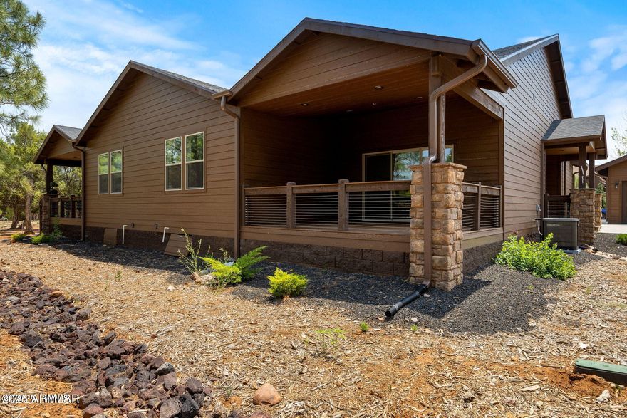 Tucked inside a scenic golf community near lakes and hiking trails, this stylish villa offers the perfect mix of comfort and adventure. The spacious Great Room welcomes you with vaulted ceilings, a stone fireplace, and sliding doors that lead to a private covered deck surrounded by nature. The open kitchen features custom cabinetry, granite counters, a breakfast bar, and stainless steel appliances—ideal for effortless entertaining. The split floor plan creates privacy, with a spacious primary suite on one end that includes a large walk-in closet and en suite bath. Two guest bedrooms, a full bath, and laundry room sit on the other side. Relax on the covered back patio or explore the outdoors just minutes from your door. Designer lighting, neutral tones, and quality finishes .. complete the feel of elevated, easy living. MOVE IN READY