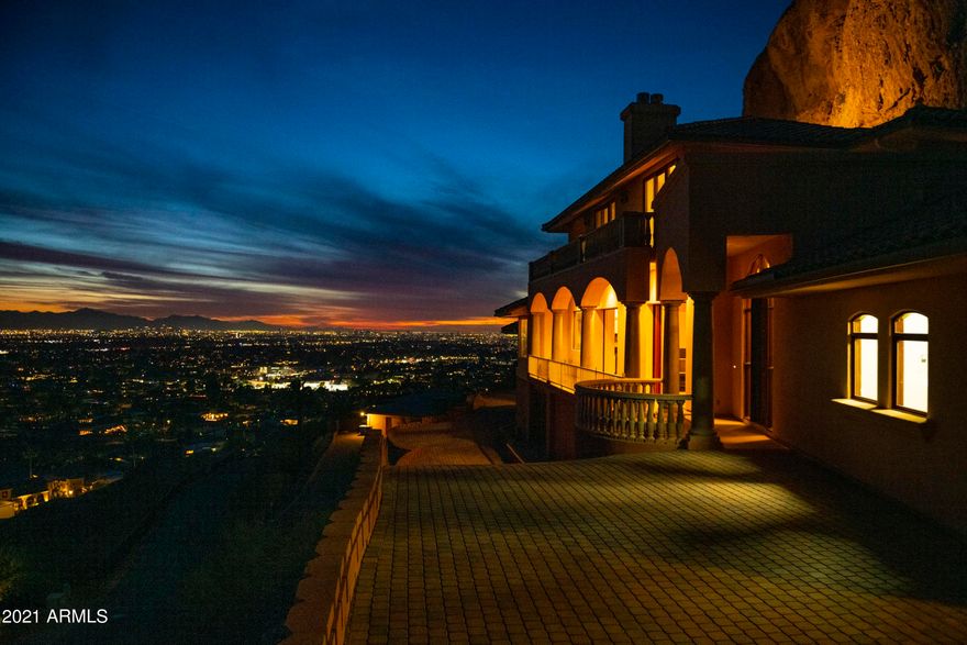 The Camel's Eye could be your backyard! Nestled on a Camelback Mountain ledge is this imposing three story walkout home offering a sweeping panoramic view of the valley and breath-taking sunsets. Amazing construction and gracious entertaining. You'll enjoy showing off your auto collection inside the 6+ stall mountain cave garage & partying with dozens of your friends in the red-rock-wine cellar. The main great room has 12' ceilings and a fully retractable window wall which leads to a paver viewing deck. Upper level owner suite has a wrap-around deck. Total of 5500 square feet, 3 bedrooms, 5 ba, multiple living areas. Room for a future infinity pool. This is the only one in the world and a rare chance to live in it, remodel it, or add to it! Some photos digitally enhanced to show options.