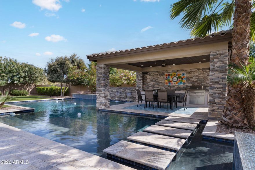 Welcome to 5,000 SQFT of refined luxury and thoughtfully curated upgrades in the exclusive Dorada Estates by Toll Brothers. This exceptional residence is perfectly positioned between Gilbert and Queen Creek, offering convenient access to the premier amenities of both communities. The primary suite is thoughtfully located on the first floor, along with a private office and an additional bedroom ideal for guests, multigenerational living, or flexible use. Set on nearly half an acre of lush, manicured grounds, the home welcomes you through a charming courtyard entry with a cozy fireplace, leading into an open floor plan enhanced by elegant French doors. Inside, soaring tray ceilings and expansive sliding pocket doors create a seamless flow from the family room to the backyard, framing a resort inspired oasis designed for both relaxation and entertaining.
Step outside to discover an 8' heated diving pool with central steps, an above-ground spa, and a gazebo with a built-in outdoor kitchen. Mature landscaping surrounds generous patio areas, offering exceptional privacy and serene views of the San Tan Mountains, perfect for enjoying Arizona living year-round.

At the heart of the home, the chef's kitchen is anchored by a substantial island and enhanced with high-end built-in appliances, combining elegance with functionality for everyday living and entertaining.

On the second level, three bedrooms including one with a private en suite and two connected by a Jack-and-Jill bath, provide comfort and privacy. This level also features a dedicated home theater with surround sound and projector, delivering a true cinematic experience integrated into the home's smart system.

An expansive loft-style entertainment lounge elevates the space even further, highlighted by an impressive 11.6-foot island with extensive custom cabinetry for abundant storage. The opposite wall showcases painted brick detailing, additional built-in cabinetry, and premium under-counter appliances, including a wine refrigerator, beverage refrigerator, ice maker, and sink perfectly designed for effortless entertaining. A granite countertop and integrated surround sound complete this inviting retreat.

Advanced smart home technology allows effortless control of lighting, audio, select systems, irrigation, and pool automation.

An oversized 4-car garage completes the residence, featuring epoxy flooring, extensive built-in cabinetry for organized storage, and an RV gate for added flexibility,thoughtfully balancing practicality with luxury.
Please refer to the Documents tab for a complete list of upgrades. This is a residence where architectural elegance, thoughtful design, and everyday comfort come together seamlessly.