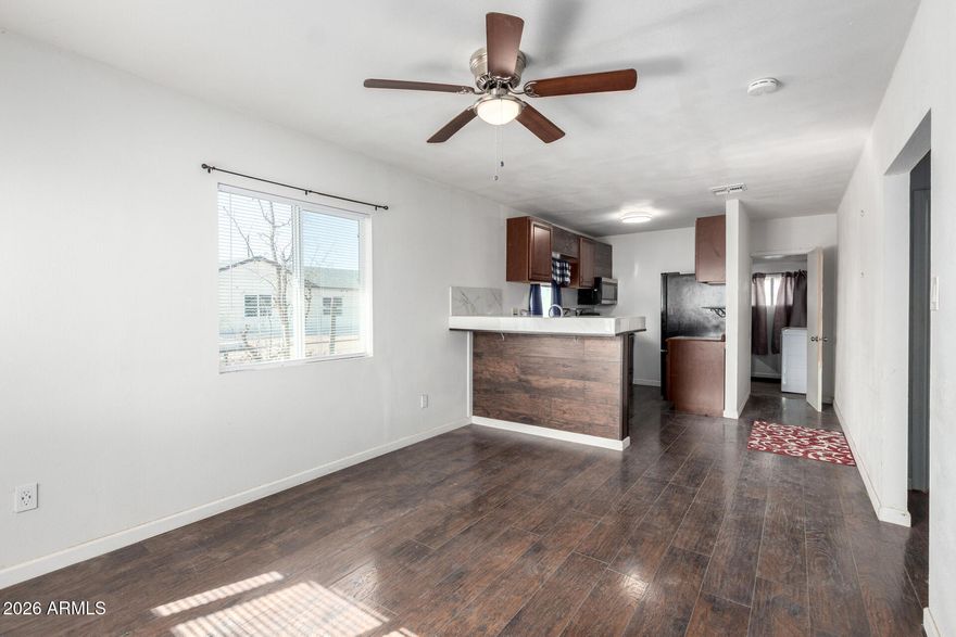 Seize the chance to own this charming 2-bedroom home in Coolidge! You're welcomed by a full-fenced lot and a front porch that sets an inviting tone. Inside, you'll find an appealing open layout with a soothing palette, blinds, and rustic wood flooring. The well-appointed kitchen includes ample wood cabinetry, essential built-in appliances, and a peninsula with tile counters and a breakfast bar for casual dining. Both bedrooms are cozy and well-sized, providing a private retreat for a good night's rest. Venture out onto the backyard, offering a covered patio, a basketball hoop, and abundant space for crafting your dream outdoor oasis. Don't miss out on this one!