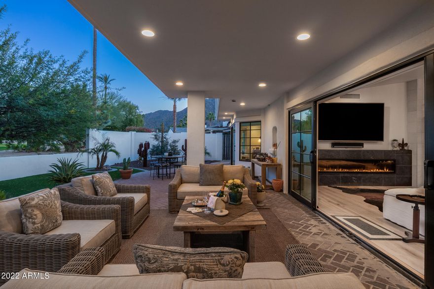 Secluded within the exclusive neighborhood of Mountain Shadows East, this home exudes warmth combined with casual elegance, and has been thoughtfully upgraded for today's aesthetic tastes.  Bold, yet simple, the subtle earth tones promote relaxation and renewed energy.  An open concept plan joins the gourmet kitchen to the living/dining areas that feature an LED fireplace.  Enjoy the clean lines, vaulted ceilings and commanding views.  The chef's kitchen with marble and satin granite surfaces and high- end appliances makes a perfect home for both intimate and large gatherings.   The primary bedroom invites the outdoors in and provides access to your private backyard oasis.  The spa - like primary bath includes a soaking tub, gorgeous walk - in shower and custom closet. Guest quarters are placed at the opposite end of the home.  This design allows perfect separation of guests from the homeowners retreat.  The exterior features a luxurious front courtyard and a magnificent backyard with gas BBQ area that offers direct access to the kitchen and a soothing fountain.  Elegant living spaces are designed to compliment our desert climate while maximizing mountain views.  Comfort, quality, and sophistication are achieved throughout the many distinctive details. A Three car garage completes the perfect home.
