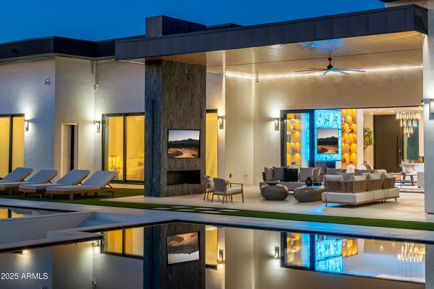 Elysium is Arizona's most advanced estate - a $15M fusion of architecture and technology rarely seen outside Beverly Hills or Miami Beach. Spanning 8,587 sq ft throughout the main house & guest house, Elysium offers 7 bedrooms (9 including the smart-glass cube and cinema) and 8 baths, crafted for those who prize privacy, precision, and presence.

The guest house is a private retreat of its own, with 2 bedrooms, 2 bathrooms, a full kitchen, laundry room, and an RV garage—perfect for extended family or long-term guests.

Outdoors, a 2,855 sq ft custom black diamond-finish pool sets the stage with an underwater backlit onyx firepit, infinity-edge spa, and Baja shelf. Host at scale with a one-of-a-kind outdoor restaurant serving 20 via swim-up dining, then screen under the stars in the outdoor theater for 100+ guests.

Inside, walls dissolve at the touch of a button: 2,100 sq ft of electronic smart glass across 55 sliding panelsthe largest residential installation in the Valleyshifts from open transparency to instant privacy. Culinary credentials include three professional kitchens, headlined by the Gaggenau Vario 400 main kitchen. Materials and millwork are uncompromising: bedrooms carved in stone and wood, pivot doors throughout, custom closets, refined fixtures, and a statement Brazilian Cristallo quartzite fireplace in the main living room that changes color. The entire estate is a Savant automated smart home, with lighting, AV, smart glass, and climate all automated and controlled seamlessly.

For the collector and competitor: two private car galleries and an air-conditioned showroom with vertical parking for up to 14 cars (with all lifts installed) deliver museum-quality presentation, while a luxury glass-enclosed sports court elevates daily play. A Dolby ATMOS 4K cinema anchors the entertainment wing.

Security here is architecture: compound-grade systems with 32 casino-grade AI cameras, automation with invisible laser trip wires across the exterior detecting fence jumps, gate openings, or driveway approach, motion sensors in every room and 1" thick laminated security triple sheet double pane glass throughout. The entry deploys a 2+ inch steel-and-glass pivot door with 13 deadbolts. At the core, a military-grade nuclear/biological/chemical safe roomengineered to U.S. Army Corps of Engineers protocolsfeatures 8" reinforced concrete, a 50,000-psi-rated bunker door, and a pressurized air system. (The space is pre-designed to be configured as a discreet server/cold-storage command center if desired.)

The grounds complete the sanctuary: 250+ specimen plants and 20 exotic mature palms form a security garden that screens the estate in lush privacy.

Elysium is not simply a homeit's a private world. For the buyer who values absolute security, rare craftsmanship, and the ability to entertain at any scale, nothing else in Arizona compares. Luxury home staging and furnishings by Vesta Home. All furniture available for purchase with the property.