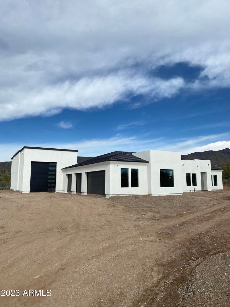 Much further along then the pictures! Getting close to completion! Amazing opportunity to be the proud owner of this modern construction newly built home sitting on a 4.5-acre lot! Single story 4 bed, 3 bath property with 2864 sq. ft. RV garage for all your trucks & toys + a 4 car garage! Fantastic modern floor plan with fabulous upgrades throughout, gourmet kitchen with upgraded appliance package, gas stove, vent hood, upgraded counter tops and cabinetry. Gorgeous flooring T/O.  Home abounds with bountiful natural light. Stunning mountain, sunset, & desert views from every room of your new custom home. Excellent Cave Creek location with lots of privacy and close to shopping, dining, & entertainment. Don't wait; this unique opportunity will not last! House colors, almost white on the body with black trim, grey roof, paver driveway, front yard landscaping.  Inside there will be gorgeous hardwood floors, 3cm quartz, mat black faucets, appliances with can fronts on them, stone on the fireplace.  More to come soon as we are getting closer to being finished with this amazing home!