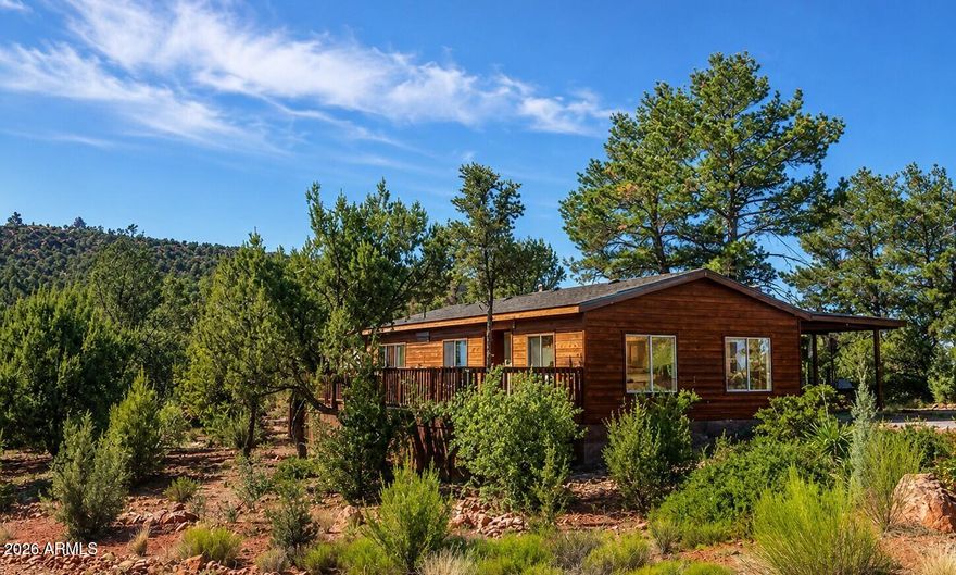 Sweet, vintage, and delightfully retro 1978  2-bedroom, 2-bath manufactured home--the lowest-priced home in West Sedona. From the paneled walls and classic wallpaper to the  charteuse green sinks and commodes, this home  embraces its original character and vintage flair. Lovingly owned by the same family since 1997 and gently enjoyed as a cherished retreat, this home offers a refreshing reminder of a simpler time. Set on a lot  with  Subdivision open space next door, you'll enjoy fantastic views from the living room, dining area, and full-length front deck.  Located just minutes from Sunset Park, National Forest trails, shopping, restaurants, and all the hustle and bustle of West Sedona, the location is hard to beat! Home offers massive tandem covered carport,  separate laundry room, and retro built in glass cabinets Whether you're looking for an affordable Sedona getaway, a vacation rental  or a nostalgic blast from the past, this home is ready to welcome you.  Roof was replaced approximately around 4 to 5 years ago.  Being sold in its current AS-IS condition, this home presents an excellent opportunity for buyers who appreciate vintage charm and want to enjoy it exactly as it is--or make it their own over time. With no HOA, and fully financeable, homes at this price point in West Sedona are few and far between! So jump at this opportunity, where it's a true throwback to a simpler era, just waiting for its next chapter! Where can you own a home with views in West Sedona under $380K? Here!  It's not the song of Sweet Home Alabama but Sweet Home Sedona!!!