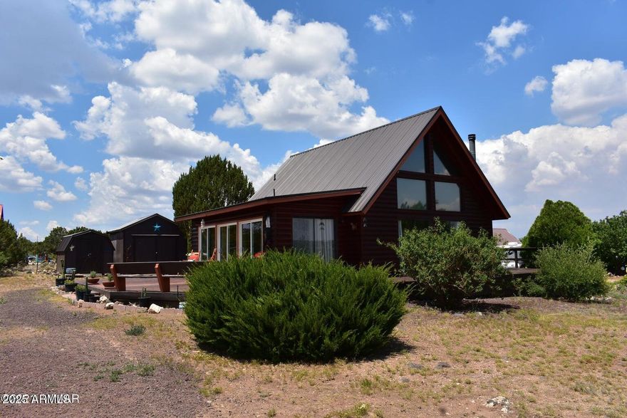 ESCAPE THE HEAT!  This is your chance to own this beautiful Mountain Cabin in White Mountain Lakes. This property has so much to offer with wonderful views in a wide-open space setting. There are many amazing exterior features that include recently stained and painted (May 2025) log siding, an expanded wood deck area(refurbished March 2026), mature vegetation, a covered porch area, privacy, and more. 2 sheds and a Connex. The fine interior print of this home has expansive lighting with large windows, vaulted ceiling, beautiful stonework, an open kitchen with tons of cabinet space, ceiling fans, sliding glass door, red oak tongue and groove flooring, wood blinds and sliding drapes, pellet wood stove with custom rock surround, loft with ample storage, but could be used as a bedroom. Custom staircase decor, and so much more! All of this on .50 acres (2 lots) Additional Parcel included in sale #304-40-073, with White Mountain Lake privileges, and a golf course that are located close by. Opportunity to purchase the 3rd lot too! Private/Restricted access to White Mountain Lake, the recreational center of the White Mountains. Fishing, swimming, boating (unlimited boat motor size), water skiing, jet skiing, golfing and hiking. Don't miss this opportunity! Home comes with 2 placards for lake access.  SOLAR PAYS FOR ELECTRICITY!
