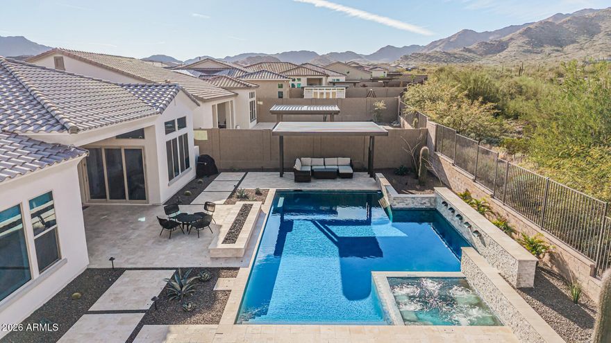 DESERT MOUNTAIN PARADISE AWAITS YOU IN THIS HIGHLY UPGRADED 4 BEDROOM/4.5 BATHROOM HOME. You'll be mesmerized by the spectacular views of the White Tank Mountains. Enter into the home and that amazed feeling continues. There is an abundance of light streaming throughout the home while the luxurious appointments will dazzle you. Eyes are drawn to the amazing fireplace feature wall, custom cabinetry, massive waterfall island, gorgeous plank-style tile flooring & transom windows that make the mountains come alive. All bedrooms have an Ensuite bathroom in this split-floorplan. Step outside to extensive patio space, both covered & uncovered, cantilevered pergola, gas fireplace, heated pool with spa & panoramic views of the Mountains and lush desert growth. You might not want to leave home. This lovely home has been gently occupied as a 2nd residence.