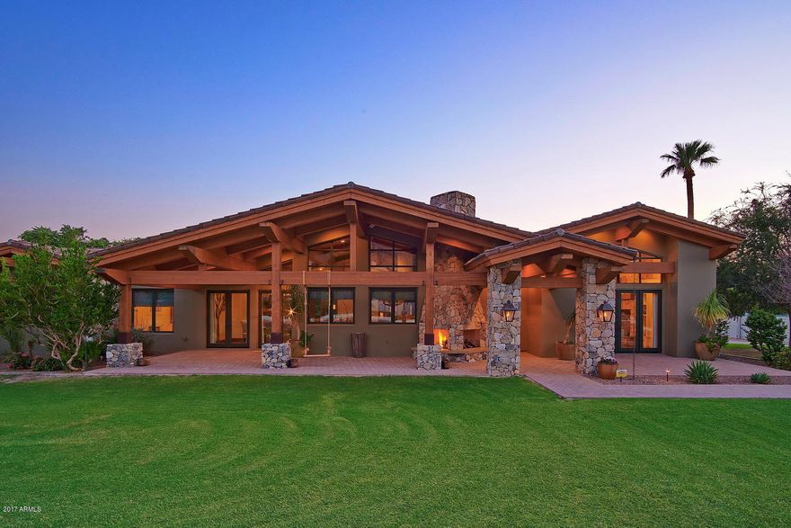 This exquisite modern ranch retreat is located on one of the premier streets in the heart of Arcadia with sweeping views of Camelback Mountain.  This home has multiple living spaces designed for both family flexibility and entertaining, with a total of 9,135 sf, comprised of 5,853 sf in the main house, 2,363 sf in the open finished basement and 920 sf in the studio/guest house. The spacious kitchen has every culinary amenity including a French Lacanche Volnay range with an artisan crafted metal range hood, dual dishwashers, dual stainless sinks, pellet ice maker and soapstone counter-tops.  The adjoining butler’s pantry provides ample storage with additional oven, refrigerator and wine cooler.   The stately living room has stunning views of Camelback Mountain. Every bedroom and bath is lovely, each having its own special attention to detail to include walk-in closets. The studio/guest house has a separate entry with garage, laundry area, outdoor shower with views of lap pool, patios, fireplaces and grounds. The home has the highest quality construction materials and finishes, many are eco-friendly and "Green" certified. Some of the upscale finishes include custom built-in cabinetry in every room, imported hand painted tile, soapstone and exotic wood counter tops, soaring vaulted wood planked beam ceilings, stone fireplaces, brilliant lighting, and wide planked hardwood flooring. The grounds include numerous entertaining patios, a large Ramada with stone fireplace, an amazing resort style pool, set beneath impeccable Camelback Mountain views.  Flood irrigation is available from Arcadia Water.  These details begin to tell the story of the captivating and creative design elements that are throughout this home.  Please see FEATURE LIST located in the DOCUMENT TAB.  This property has it all....