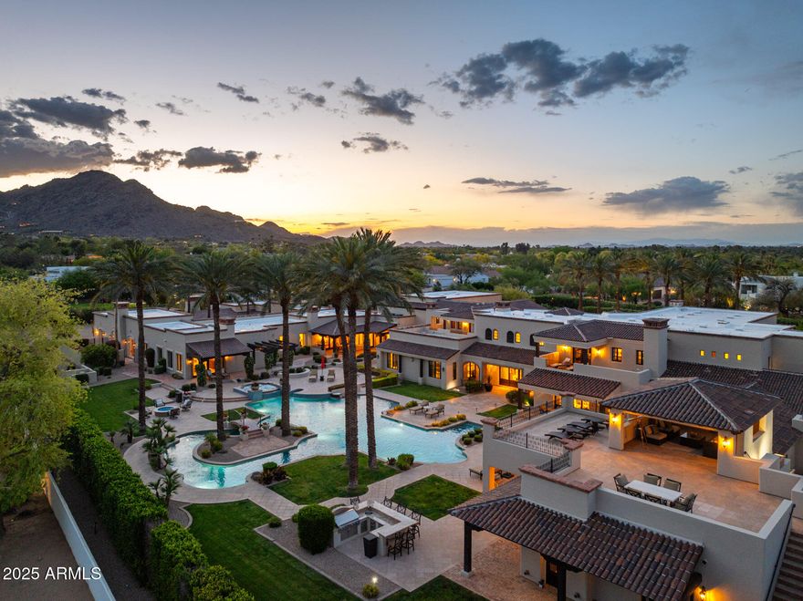 Luxury meets livable elegance in this Paradise Valley estate on coveted Cheney Drive. A grand foyer opens to soaring ceilings with arched entryways, exposed wooden beams, and sparkling chandeliers—setting the tone for timeless sophistication. Prepare to be captivated by the spiral staircase and remarkable amenities including an indoor sport/pickleball/basketball court and private home theater. The chef's kitchen features a full back kitchen, premium appliances, a generous island, and a formal dining room. The primary suite is a true retreat with dual vanities, dual closets, enclosed toilets, an oversized shower, freestanding tub, and a private courtyard. Enjoy seamless indoor/outdoor living in your resort-style yard with custom pool and spa, multiple BBQ stations, mature landscaping, and a private viewing deck for breathtaking mountain views. A detached guest house offers exceptional privacy. Just minutes from Arizona's top resorts, golf, dining, and shopping.