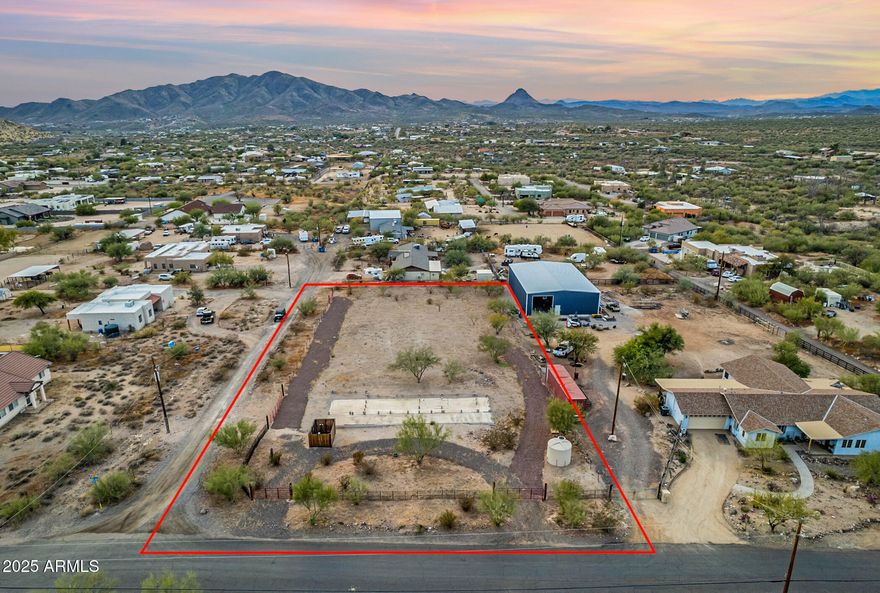 RARE FIND! OVER-SIZED 1.14 ACRE FULLY FENCED LOT. One-of-a-kind parcel with 360° Mountain Views. Property is BUILD READY - Features Include: 26' x 68' CONCRETE SLAB, 1250 Gallon SEPTIC TANK, 3000 Gallon WATER HOLDING TANK, 200 AMP power service with 50 amp, 30 amp, and x4 20 amp RV HOOK UPS. Land includes FOUR RV GATES (12-32 ft) for easy access! Boundary & Topographic Survey Available. NO HOA - Plenty of room for your RV, Boat, Trucks, or Trailers! Located just miles from LAKE PLEASANT, HIKING TRAILS, ATV/JEEP TRAILS, AND MORE! This recently improved land is READY FOR YOUR DREAM HOME!