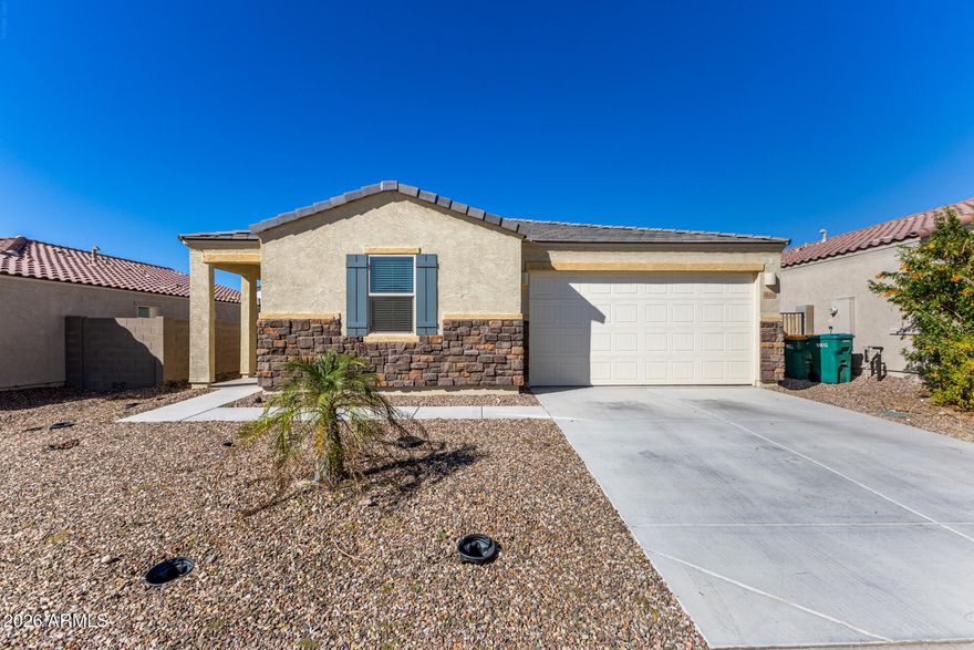 Enjoy modern desert living in this beautifully upgraded 4 bedroom, 2 bath 2023 build in Gold Canyon. The open kitchen and living room layout creates a bright, spacious environment ideal for everyday living and entertaining. Upgraded tile flooring runs throughout, and the thoughtful split floorplan offers privacy with the primary suite separated from the additional bedrooms. The primary retreat features a full bathroom with dual sinks and a large walk-in closet, while the guest hall bath also includes double sinks. Step outside to a well-designed backyard perfect for entertaining, complete with a covered patio, patio pavers, turf, and low-maintenance landscaping with front and back irrigation. Additional features include numerous builder upgrades, water softener, and garage shelving.