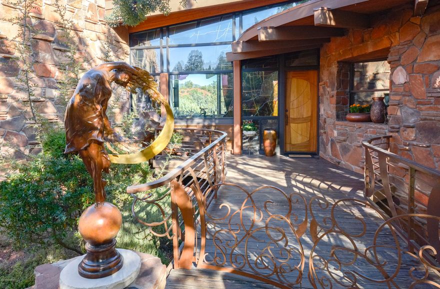 This home is a masterpiece created by the coveted Design Group. It has a curvaceous contemporary impression that combines the natural elements with artistic color and movement. Set in a private, peaceful location among the junipers and pines with panoramic red rock vistas. Precision use of natural stone, wood, custom iron, and stained glass by famous artist Aderhold, makes this a one-of-a-kind home of timeless elegance. Living room draws you in with the picture windows filled with red rocks. Stone fireplace and built-in curved seating are romantic touches.  Kitchen is equipped with everything a gourmet would need. Master bedroom has wonderful views, fireplace, walk-in shower, and a serene spa patio. Featured in Sedona Magazine and other publications for its complete Sedona essence. More.. The cathedral ceiling in the turret office will amaze you with open wood beams and natural lighting. View decks and the surrounding nature will invite you to explore all the nearby trails. The entry welcomes guest over a whimsical bridge with iron gates and a peaceful water feature. Many meditation patios dot the property between the trees and rock outcroppings. The properly equipped extra-large 3 car garage has epoxy floors and plenty of workspace to complete the home. What are you waiting for?