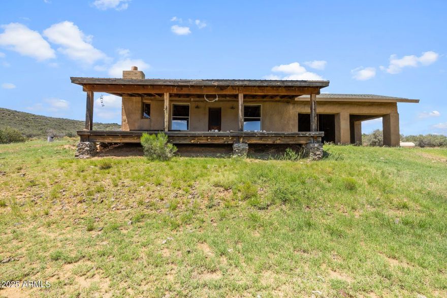 Discover sustainable living with panoramic views in every direction! Nestled on just under 20 acres of patented land, this 1,224 sqft straw bale home with 864 sqft garage offers an eco-conscious lifestyle with modern comfort and unique off-grid potential. Built with 48'' x 12'' x 16'' thick straw bale walls then covered with concrete, this home provides incredible insulation, keeping it cool in summer and warm in winter — often needing no additional heating or cooling. When needed, enjoy a cozy wood burning fireplace and energy-efficient ceiling fans powered by a generator or install a solar system that is already wired for inverter and panels. Basic kitchen with propane stove gravity-fed hauled water, copper countertops. Additional features Pre-wired for solar - just add panels, inverter, and marine batteries or generator backup, Efficient tankless water heater, Compost toilet ( no septic installed ), Modern shower setup, and includes patented mining claim. This self-sufficient home is ideal for off-grid living or a retreat from the ordinary. The solar system will need to be installed for financing, but the infrastructure is ready  just plug and play. Whether you're a homesteader, minimalist, or investor, this rare property blends sustainability, privacy, and freedom in one of Arizona's most beautiful high desert landscapes.