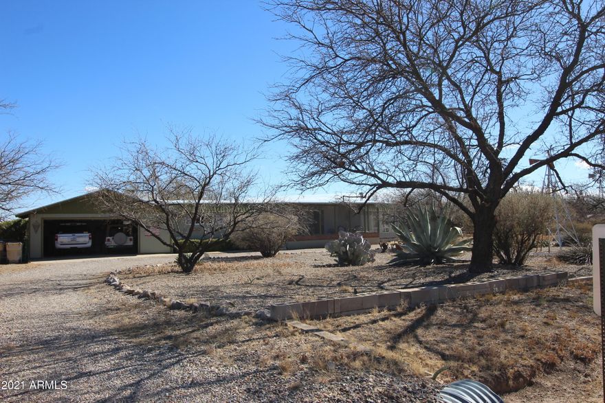 This 2 bedroom 2 bath home features
 3 porch areas to take advantage of the wonderful Arizona weather. Wood burning stove for those chilly evenings. Over 1400 sq ft gives you lots of room inside. All on 1 Acre!  Located on paved roads, has a 2 car attached garage with extra large workroom. Complete RV hook up for your winter visitors. The garage received a new roof and house was cool coated in 2018. All new plumbing in 2013. Carpet replaced in 2018. This home is ready for new owners!  Give me a call to schedule your private  showing today