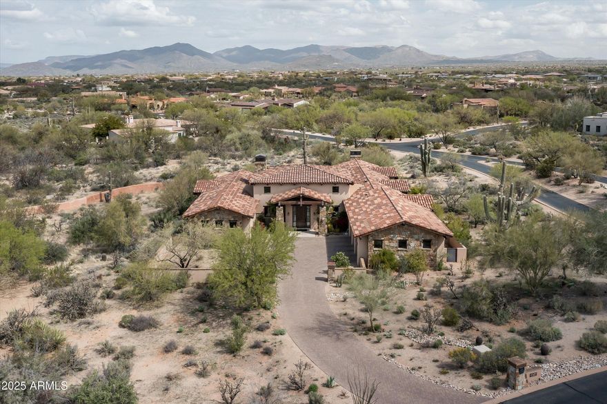Situated on a private corner lot surrounded by pristine desert landscape, this stunning home is the perfect blend of desert ranch architecture and modern luxury. The open great room features soaring beamed ceilings, reclaimed hardwood floors, and a massive glass wall that effortlessly opens to the backyard. The home boasts two primary bedrooms, each with its own en-suite bathroom, as well as two additional guest rooms and a separate casita that functions as the 5th bedroom. A wet bar, conveniently located in the open great room is perfect for entertaining. The large kitchen is a chef's dream, featuring dual islands, ample counter space, and high-end finishes, ideal for both casual dining and hosting guests. For ultimate outdoor enjoyment, the backyard is centered around the heated pool and spa, an outdoor fire-pit, and a built-in BBQ. The guest house, complete with its own fireplace, offers additional space for your guests. This exceptional property is designed for those who appreciate fine details and seamless indoor-outdoor living, all while enjoying the peace and tranquility of a private desert setting.