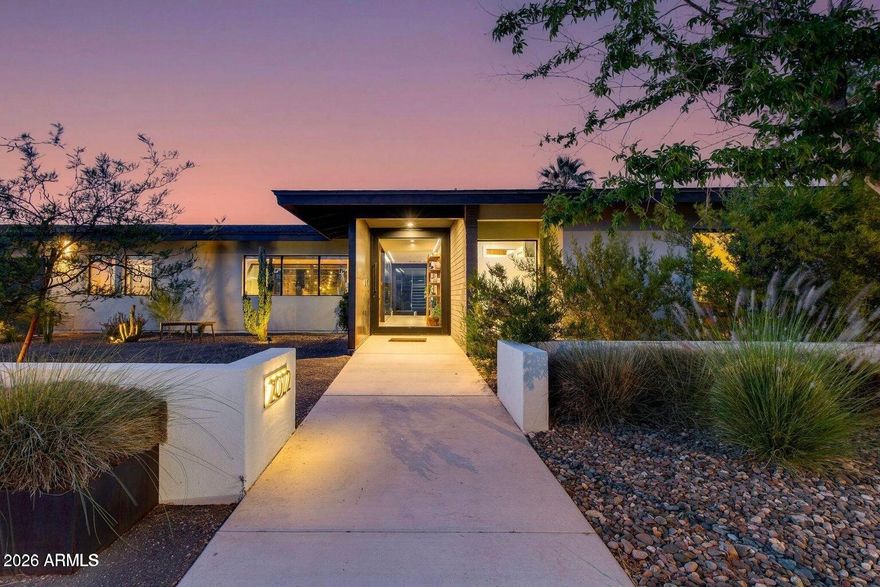 Fully reimagined in 2021, this architecturally striking 5 bed, 3.5 bath residence blends modern design with warm, organic finishes. Flooded with natural light, the open-concept layout is anchored by soaring cathedral ceilings, dramatic steel elements, and exposed block details that create a bold yet inviting aesthetic.
At the heart of the home, the kitchen makes a statement with custom wood cabinetry, sleek black granite countertops, an oversized island, and premium stainless steel appliances. 
Expansive sliding glass doors dissolve the boundary between indoors and out, opening to a private backyard complete with a salt water pool, curated desert landscaping, and multiple areas to unwind or entertain. 
Two spacious primary suites include patio access, walk-in showers with freestanding tubs and walk-in closets. A rooftop deck captures sweeping mountain and city views, delivering a rare vantage point and the perfect setting for sunset gatherings. A three car garage offers ample space for storage. 
This is modern desert living at its finest.