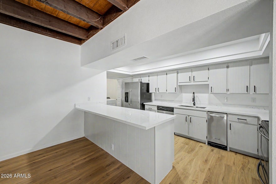 Tucked within the prestigious Goldwater Lake community, this fully reimagined residence offers a rare blend of privacy, sophistication, and effortless living. Featuring 3 bedrooms, 2 bathrooms, and a 2-car garage, the home is appointed with wide-plank luxury vinyl flooring, spa-inspired fully tiled showers, designer fixtures, and curated lighting throughout. Dramatic high-beam ceilings elevate the space, creating a light-filled, open ambiance. The private side yard and secluded backyard offer a tranquil retreat, ideal for both intimate gatherings and refined entertaining. Unwind in your built-in spa and enjoy a low-maintenance outdoor lifestyle. Moments from scenic lakes, walking paths, and community amenities, this home delivers elevated living in one of the area's most coveted settings.