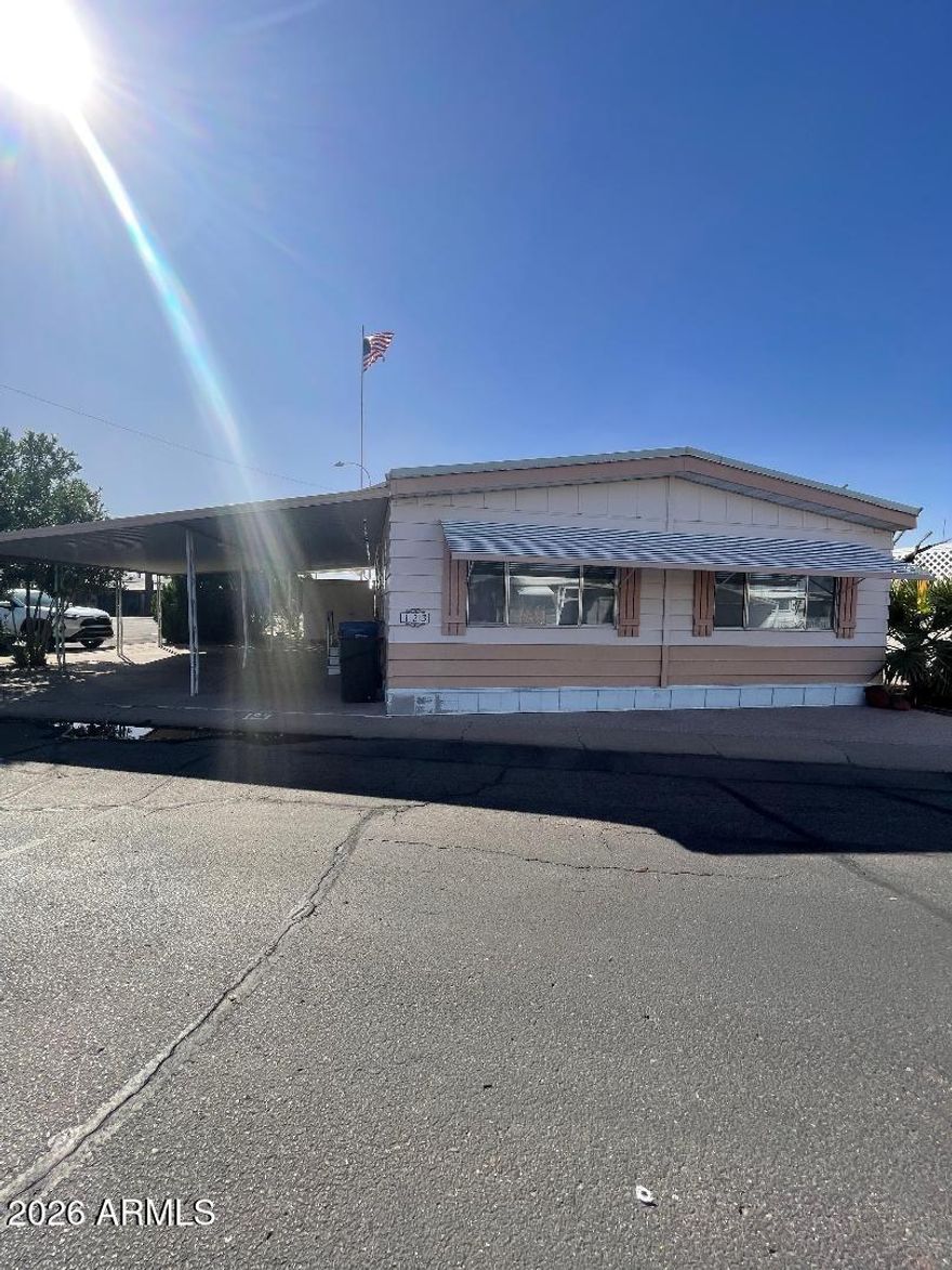 A rare doublewide home in the desirable 55+ community of Deserama Mobile Ranch Park. Located a few steps across the street from the community pool and center! Drive into your covered carport with shade bushes on the side for privacy and an epoxy covered floor. This well maintained home has brand new carpet with LVP flooring in kitchen and bathrooms, new paint, plus it includes the washer/dryer/refridgerator and all window coverings making it move in ready! This home has an abundance of storage areas and closets including a beautiful built in hutch in the dining area. Enjoy the outdoors on a large covered front patio next to the 1 car carport and an 8x8 storage shed that is easily accessible from the patio.