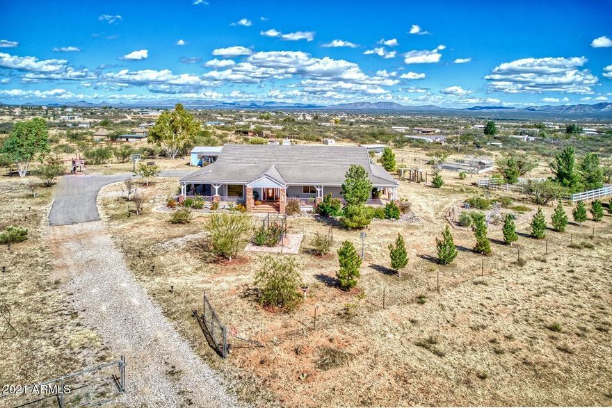 Upon arrival you'll notice the inviting wrap around deck perfect to appreciate Mtn Views & AZ colorful sunrises & sunsets. Land is fully fenced & has a pond, children's playset, multiple areas for farm animals & a workshop w electricity & 1/2 bath, could be converted to a casita or use for anything that fits your lifestyle. You'll love the spacious & bright open kitchen, dining, living room space, a double fireplace that divides living room and family room, master bedroom with its own fireplace & walk in closet, master bath w jetted tub & walk in shower,3 additional bedrooms & 2 baths for a total of 4 bedrooms & 3 baths, ample laundry room and large pantry. Central vac, speakers inside & deck area are some extras. XL 2 car garage with plenty of storage completes this wonderful custom home