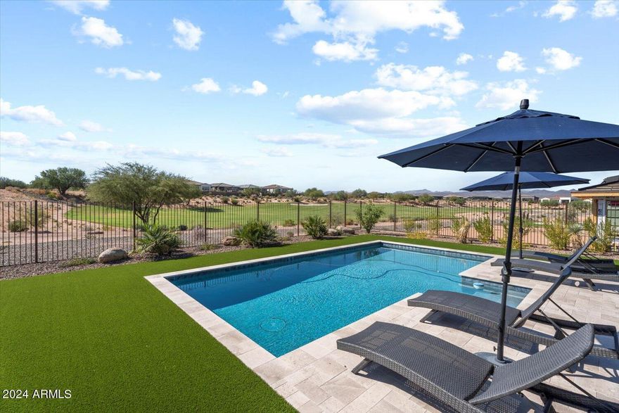 STUNNING GOLF COURSE LOCATION AT TRILOGY VERDE RIVER. MANY UPGRADES TO THIS 1-YEAR-OLD HOME. Situated on the 14th fairway, this 2161sf Brasada plan has 2 beds + den, 3 baths, a heated pool, golf course & mountain views. Park-like setting with carefree turf front/back & 550sf covered back patio for entertaining.
 Open floor plan w/ custom flooring and 8' 6-panel doors. Large primary en-suite, walk-in closet & bath w/ custom glass shower + tub. Office/den with double doors. 3 wall-mounted TVs convey.
 Upgraded kitchen appliances, recessed lighting, pendant lights, soft-close cabinet doors & drawers, artwork lighting package. All countertops top of line.
  Smart space laundry with full cabinets. 580sf 3 bay garage with separate Mini Split AC unit. Perfect for home gym/art studio/workshop.
