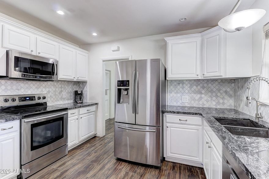 Prime Biltmore/Arcadia Lite location near Madison schools, surrounded by multi-million dollar homes. Fully remodeled w/ contemporary finishes & historic neighborhood charm. Open layout features wood-look tile flooring, premium sound-reducing windows, added insulation, recessed lighting, granite counters, marble backsplash, updated cabinetry & stainless appliances. Bathrooms offer stone/tile surrounds updated finishes. Rare for the area-primary suite includes a large bath and walk-in closet. Brand new garage door & paint. Large irrigated yard w/mature trees, privacy landscaping, screened patio, & abundant parking with carport, garage, and extended driveway. Beverly Park location with quick access to Biltmore, Downtown, Arcadia, Scottsdale, dining, shopping, trails, canal paths, & freeways. This home offers strong value for the area, combining extensive upgrades, space, a large irrigated lot, abundant parking, and features that are increasingly difficult to find at this price point.

Recent improvements include updated plumbing and electrical, fresh interior paint, brand new garage door just installed, premium sound-reducing windows, additional insulation, sealed ducts, shade screens, recessed lighting, ceiling fans, and contemporary finishes throughout. 
These upgrades contribute to energy efficiency, interior comfort, and a surprisingly quiet living environment.

Additional features include interior laundry, bonus/storage space, mature shade trees, and newly installed privacy landscaping.

The carport may offer potential for future conversion to a garage or additional living space. Detached side-entry garage may provide future expansion opportunities or other potential uses, subject to buyer verification of zoning, permits, and feasibility.

Conveniently located near Biltmore shopping, fine dining, coffee shops, parks, entertainment, hospitals, Downtown Phoenix, Arcadia, Scottsdale, canal paths, mountain preserves, and major freeway corridors. Enjoy excellent freeway access without being directly adjacent to a freeway interchange. Centrally located with easy access to everything, while still offering privacy and comfort inside the home.