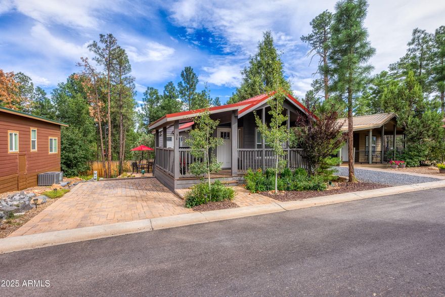 Your ideal summer retreat from the desert heat, where cooler summers and peaceful living await! Welcome to your perfect mountain escape in the highly sought-after 55+ Woodfield community, nestled in Arizona's stunning White Mountains. This spacious park model offers 1 bedroom, 2 bathrooms, plus a versatile bonus room with its own private entrance - ideal for a home office, guest space, craft room, or whatever your heart desires. Enjoy open-concept living filled with abundant natural light, highlighted by a charming bay window overlooking the wrap-around porch. The interior features stylish vinyl plank flooring in warm brown tones, dimmer switches on both interior and exterior lighting, and thoughtful touches throughout including custom blinds for the front door, back door, and both... bathroom windows. A metal wall coat rack with a convenient storage basket adds function and style at the entrance. The well-appointed kitchen is designed for both beauty and functionality, featuring stainless steel appliances, an apron-front farmhouse sink, and plenty of space for cooking and entertaining. A stacked electric washer and dryer provide added convenience, while both bathrooms are equipped with modern walk-in showers. Step outside to truly appreciate this property's unique setting. With no homes permitted behind, you'll enjoy uninterrupted views of majestic Ponderosa pine trees. A natural wash borders the property and flows beneath the fence toward White Mountain Vacation Village, enhancing the sense of privacy and connection to nature. The outdoor space is beautifully finished with a paver driveway, paver entrance, and a paved patio complete with a 4-top table and umbrella - perfect for relaxing or hosting guests. The landscaping is equally impressive, featuring mature shrubs and trees, a perennial wildflower bed, and a drip irrigation system for easy maintenance. The expansive wrap-around porch and charming outdoor sitting areas provide multiple spaces to enjoy the cool mountain air year-round. Whether you're looking for a seasonal retreat or a full-time residence, this home offers comfort, style, and a peaceful setting. Woodfield is known for its well-maintained grounds, towering pines, walking paths, and welcoming community atmosphere. Plus, you'll enjoy convenient access to nearby lakes, trails, shopping, and more. Don't miss the opportunity to own this beautifully upgraded mountain getaway - your perfect blend of nature, comfort, and community awaits!