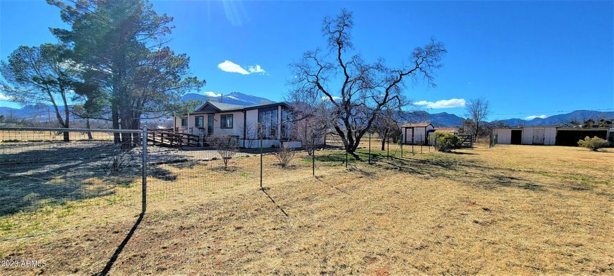 Here is a great opportunity for a reasonable priced home on 1 acre with some horse facilities. The property is fenced and cross fenced and has a loafing shed and tack room area. There is also a 2 car carport as well. The home has a great floor plan with an open living area and builtins in the dining room. The refridgerator. washer and dryer all stay with the home too. There is a wonderful Arizona room in the back with a separate storage area at one end. This home has 2 bedrooms and 2 baths. The master suite is very cute and has a large walk in closet. I know that you will love the wonderful mountain views too. Come and make this wonderful home yours! The home does need updating and some repairs. The price is reflective of this. The seller is unable to make any improvements or repairs.