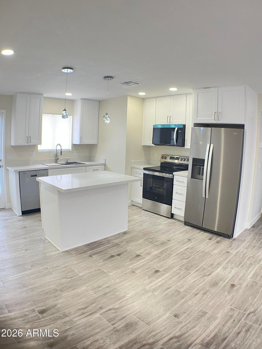 Don't Miss out on this Beautiful Home!Great Location blocks from Grand Canyon University!.  Dynamic Remodel. Look at Pics! Open, light and airy with designer finishes. White shaker Pro Craft cabinets. 42'' uppers, New  water heater & Whirlpool Appliances, Custom Quarts Countertops. Spa like bathrooms. New Tile floors, tall baseboards, new fixtures throughout. Nothing left for you to do! Just move in and enjoy! Large. Master w/walk in closet, Private Fenced and gated yard updated great for BBQ or just lounging. Hard to find 2 covered parking spaces right next  your  gate. Most others give you one space and often far from your door! Beautiful community pool. Large exterior storage! Quick access freeways, I-17, I-10, Loop 202 really quick. Low HOA includes common areas. Townhouse not a Condo!