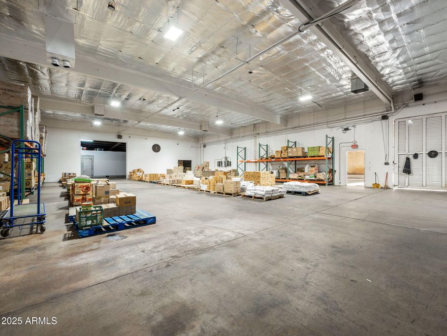 TREMENDOUS OPPORTUNITY AND VALUE! Almost 16,000 sq ft under roof! Apprx 12K sq ft interior space and apprx 3,600 sq ft loading bay. Huge warehouse space in strategic Phoenix location is impossible to find. Clean Phase 1 Environmental in July 2023. 2 bay covered semi loading dock with (2) 12 x 12 rolling doors and (1) 12 x 16 sliding door. Fenced parking - 8 spaces. Property is perimeter fenced as well. Complete interior insulation installed - 2023.  Commercial kitchen with both a 20 x 25 walk-in freezer and 20 x 25 walk-in cooler. Office Space! Retail Space! Showroom Space! (2) restrooms - ladies room has a shower and washer / dryer. This property is clean, clean, clean. ** WATCH VIDEO! **  Security system w/ cameras. Outstanding location! Easy access to I-17, Hwy 60 and I-10.
