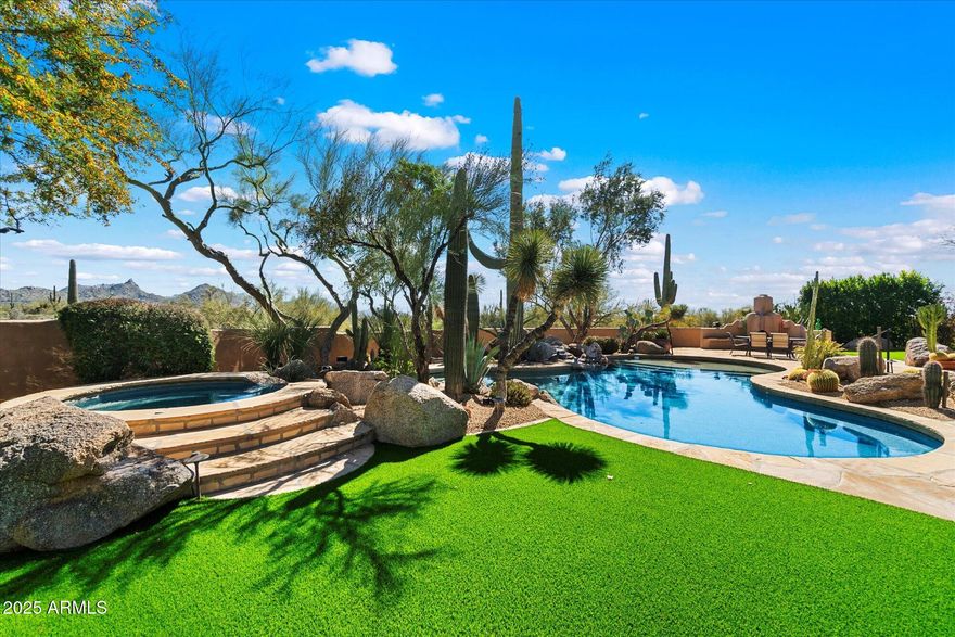 Gated Hacienda Estate with lush, manicured, park-like grounds and great views including Pinnacle Peak. Custom 4.7 acre compound has 3 ensuite bedrooms in main house, with a family room/studio, an office, a chef's kitchen, and 2 powder rooms. There is also a separate guest casita with beautiful tile work. The home features antique mesquite doors, hand hewn vigas, trestlewood floors, Italian pavers, and a sandstone bar. The home lives as a single story and has only one guest bedroom suite upstairs. 4 car garage with a/c, one bay currently used as an exercise room. No HOA. Come see this private Sanctuary. Horse & walking trails nearby.