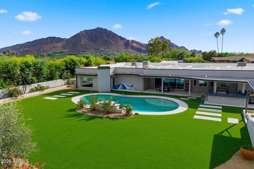 Located in the most significant neighborhood of Paradise Valley! Move right in or buy at lot value! This  totally rebuilt home with sweeping views of the north side of Camelback Mountain. This nearly 1.3-acre estate offers 5 bedrooms and 4.5 baths, plus game room! The private primary suite features a spa-like bath and is separated from a newer addition that includes a large flex room and two ensuite bedrooms--ideal for guests or multigenerational living. Entertain effortlessly in the roomy chef's kitchen and butler's pantry that open to a comfortable great room with an additional front seating area. Outdoors, enjoy an equipped kitchen, a dramatic gazebo with fireplace and pizza ovens, and ample space to add a casita, pickleball court, or extra garage. Close to everything that is PV