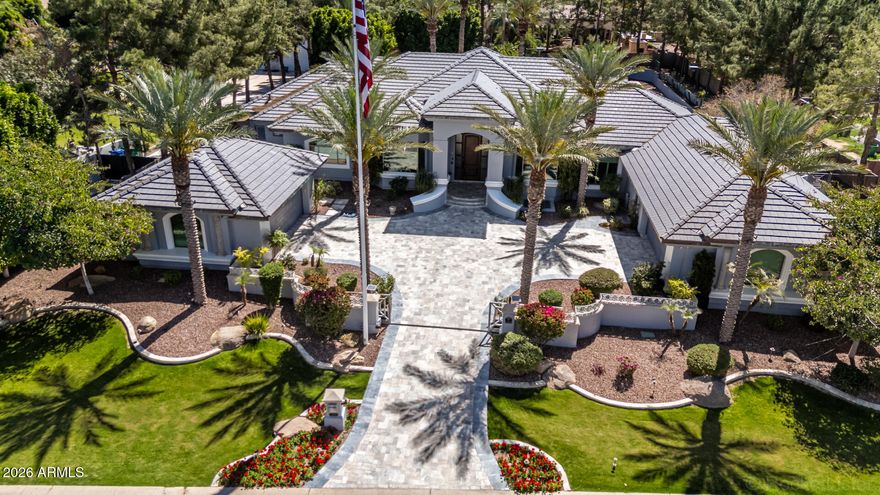 Introducing a truly exceptional custom estate where grand scale, refined finishes, and resort-style living converge making it nothing short of extraordinary.

Privately set on an expansive, lushly landscaped lot, this residence immediately impresses with its commanding presence and thoughtfully designed layout. Inside, soaring ceilings and curated architectural details create a sense of effortless elegance, while walls of glass frame breathtaking views of the backyard oasis. The formal living spaces are both elevated and inviting--anchored by a dramatic coffered ceiling, statement lighting, and floor-to-ceiling drapery that add depth and sophistication. Natural light pours in, seamlessly connecting the indoors to the resort-style exterior beyond.

At the heart of the home, the designer kitchen is a true showpiece--crafted for both everyday living and high-end entertaining. Featuring custom cabinetry, striking stone surfaces, an oversized island with rich, contrasting finishes, and Sub-Zero & Wolf appliances. Designer lighting and panoramic backyard views elevate the entire experience, creating a kitchen that is as functional as it is visually captivating.

The outdoor living is where this estate truly sets itself apart. Designed to rival a private resort, the grounds showcase a sparkling beach-style pool with a slide and water features, expansive stone patios, mature landscaping, and multiple areas for lounging and entertaining. A full-size private tennis court adds a rare and coveted amenity, while the scale of the lot provides both privacy and endless opportunity for recreation.

Adding to the home's versatility and livability, a fully finished basement offers an entire additional level of refined space--complete with a secondary living area, multiple bedrooms, a private gym, and a flexible bonus room ideal for a theater, game room, or additional office. This lower level creates the perfect environment for multi-generational living, guests, or a private retreat within the home.

Every element of this residence has been carefully curated--from the bespoke finishes and grand proportions to the seamless indoor-outdoor flow--offering a lifestyle defined by luxury, comfort, and distinction.

A rare opportunity to own a statement estate in one of Mesa's most desirable neighborhoods, where every detail has been elevated to deliver an unparalleled living experience.