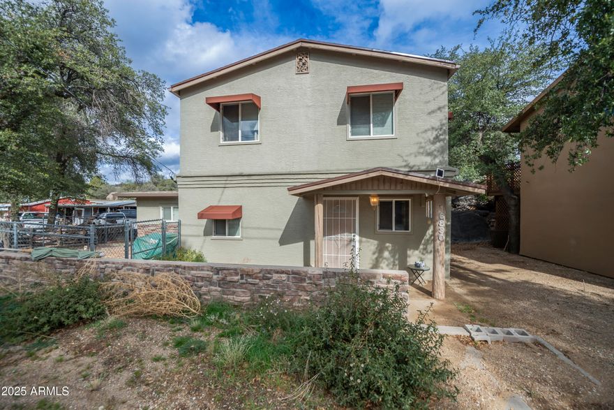 Completely remodeled 2-bedroom, 1 ¾-bath home nestled among the stunning boulders of Yarnell. This unique two-story home combines modern updates with distinctive charm, featuring new tile floors, kitchen cabinets, appliances, and bathroom fixtures. Elegant design touches include an Art Deco tub, stained glass window, copper accents, and unique lighting throughout. The main levevl (downstairs) has a pellet stove for auxillary heating. Upstairs, French doors open from the cozy sitting room to a spacious deck, perfect for relaxing or entertaining while taking in the tranquil surroundings. Recent improvements include a new roof (2024), new electrical panel, updated plumbing and wiring, and a property water shut-off valve. The flexible floor plan and inviting outdoor space with trees and boulders make this home a perfect retreat. Easy to show and move-in ready.