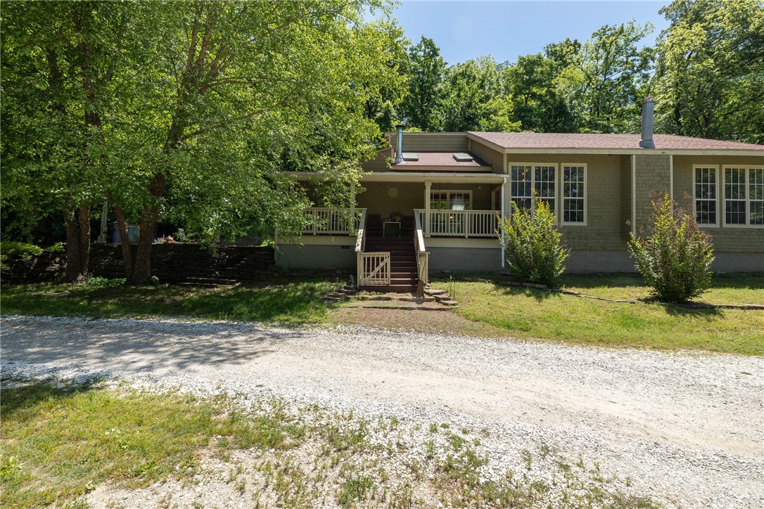This tranquil 4-bed, 2.5-bath home, 15 min from Fayetteville & the U of A, nestled on 12.86 wooded acres, features vaulted ceilings, exposed beams, wood-burning fireplaces & hardwood floors throughout. A gourmet kitchen boasts granite counters, custom cabinets & large island perfect for gathering. Tall living room windows allow expansive views of the mountains & a separate den opens onto a private back porch. The large main suite, w/ custom walk-in closet & French doors leading to the main patio, overlooks the spring-fed pond & woods. Enjoy the cedar sauna, peaceful covered porch & mature fruit trees. Large cleared fields, a 3-sided hay shed & chicken coop provide a perfect place for horses/livestock. A 30'x50' detached shop/garage wired for 30A offers room for hobbies, RV, or storage. Devil's Den & Riverside Park satisfy all your mountain biking, hiking, and river-soaking dreams within a few minutes' drive. Whether youāre craving privacy, space to garden, or a quiet homestead, this extraordinary property delivers.