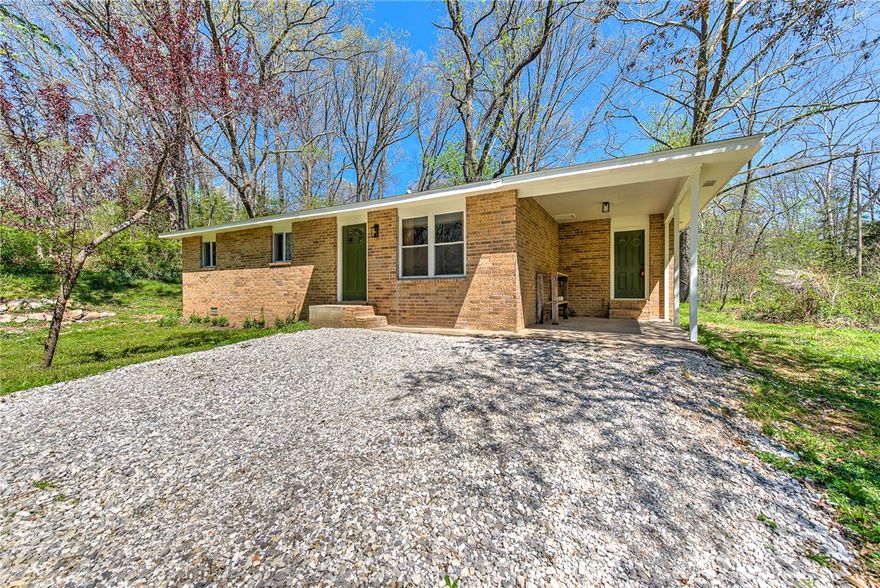 Discover the perfect blend of country charm and modern living in this beautiful updated brick home on 3 scenic acres, with thoughtful updates throughout.

A 1/4 mile maintained hiking trail winds through a canopy of mature trees and includes an elevated yoga platform to unwind and take in the natural beauty. Additional features include a fenced dog run area and a storage shed.

Downtown Rogers is just 10 miles away and less than a mile from the 4300 acre Pea Ridge Military Park with miles of hiking, biking, horse trails. Modern comfort in a truly stunning natural setting with easy access to town, and unlimited recreation at your doorstep. Welcome to this lifestyle retreat!