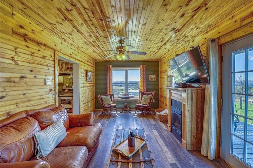 Cabin on 21.8 m/l unrestricted acres! 3 BR, 2 full BA cabin built in 2012 is just what you've been looking for! Coffee tastes better on the covered front porch as the sun rises, and evenings? They belong on 1 of 2 back decks with those big, bold sunset views that never get old! Inside you will find an updated kitchen featuring butcher block tops, gas connection for the stove, and an inviting layout that flows right into the living room that features a gas fireplace and new LVP.  But the primary suite… that’s where things get downright irresistible! Think claw-foot soaker tub, a roll-out window that lets the fresh country air in while you relax, an electric fireplace for a little extra ambiance, and a custom-built vanity that’s truly one-of-a-kind. The suite also opens directly to your private upper deck!  Outside you will find peach trees, pear trees, a pond, wildlife—deer, turkey, and more—makes this property feel like your own private nature preserve. There’s also a shop building and a brand-new roof in 2025.
