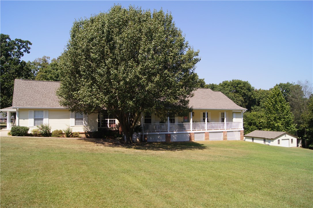 One owner custom built charming home on beautiful tree canopied 4.6 acres. This home offers an attached 600 sqft guest suite with a separate entrance, complete with kitchen, living room, bedroom, bath, washer, and dryer. Game room above garage with separate A/C. 800 sqft detached workshop, garden area, walk out basement storage, and 2 car garage. Beautiful setting and close to town. Recent property updates include new roof, hot water heater, and A/C units in both the main house and in-law suite. Property eligible for RD Loan.
