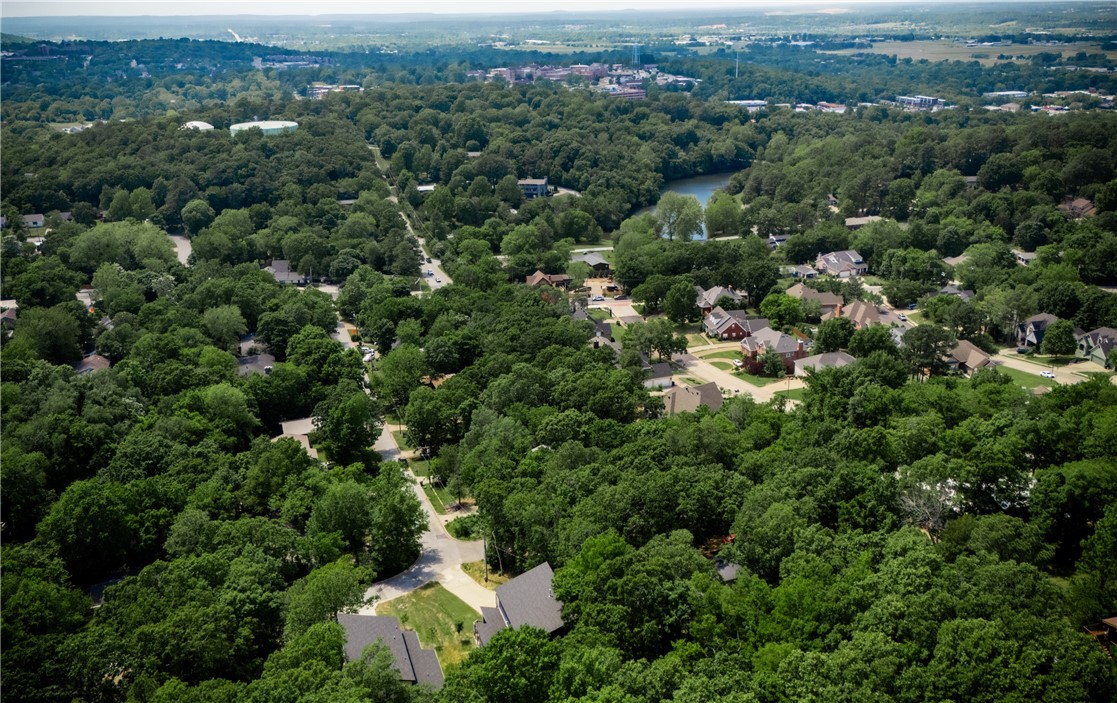 Stunning Hilltop Retreat with Breathtaking Views of Old Main. Perched at the top of a quiet hill near Root Elementary School, this exceptional Fayetteville residence offers panoramic views of Old Main and unforgettable sunsets from two expansive west-facing patios. Backing up to a serene wooded area filled with deer and native wildlife, this home provides unmatched privacy and a true connection to nature, all while being minutes from the heart of town. Thoughtfully designed with comfort and luxury in mind, the home features two spacious primary suites, each with a private bathroom boasting elegant tilework and freestanding soaking tubs. Modern hardwood floors, plentiful windows, and large sliding glass doors flood the home with natural light, while contemporary fixtures and premium KitchenAid stainless appliances add style and convenience.The fully finished walkout basement includes a bonus room and a media space.