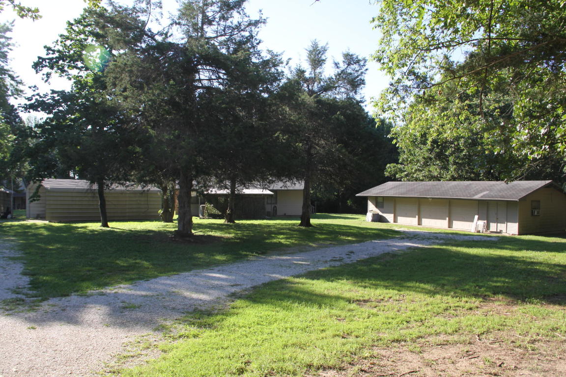 Level 6.82 acres with a 1,600 sq ft ranch style home, an oversized detached 3 car garage with workshop area, a separate work studio, and two portable carports . Private setting, approx 30 minutes to Buffalo River, 15 minutes to WalMart and 45 minutes to Branson, MO