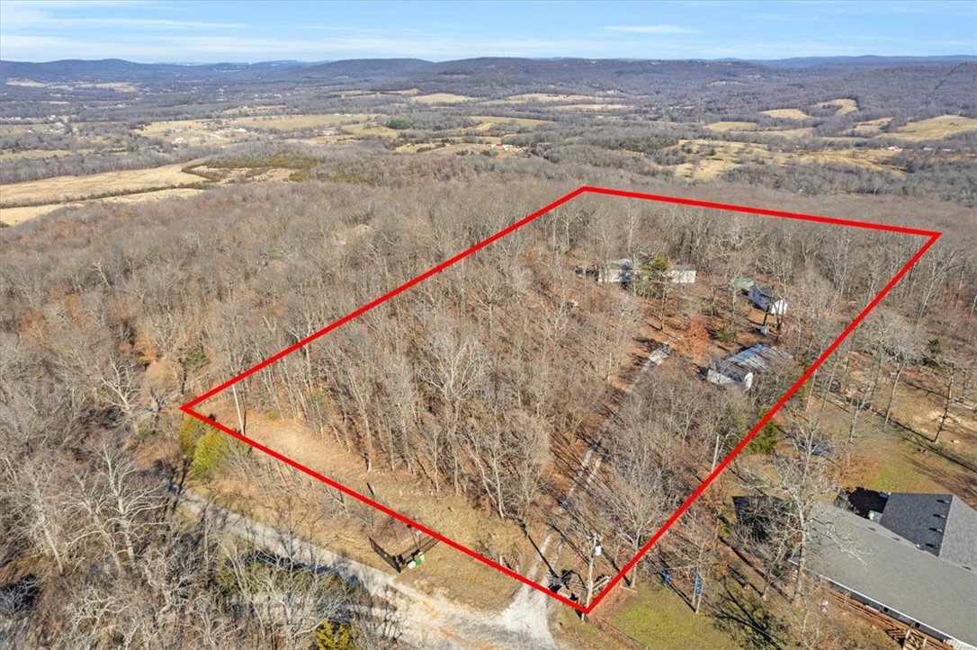 MILLION DOLLAR VIEW. MOUNTAINTOP LIVING. 270 degree panoramic vistas. Pavement all the way til last 3/4 mile. A rare find - both views and flat shelfs on this piece of land for your agricultural and building needs. Build your dream home 25 minutes from Fayetteville Square. 5 acres, no covenants or restrictions. SINGLEWIDE trailer conveys and is live-able while you build the home of your dreams. City water (Washington Water Authority), Ozarks Electric, Ozarks Go, has septic. Everything works. Will require a cash or in-house loan financing. 10 minutes to Harps, Devils Den.