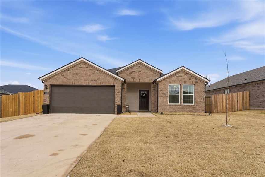 This beautifully maintained single-story brick home, built in 2023, offers modern comfort with thoughtful upgrades already in place, a large and spacious backyard, and a prime location close to downtown. Conveniently situated near the aquatic center, schools, shopping, John Brown University, and with quick, easy access to Highway 412, this home blends everyday convenience with comfortable living.
The sellers have enhanced the home with a cozy living room fireplace, added fencing for privacy, a concrete patio slab perfect for outdoor entertaining, and kitchen backsplash. Inside, the home is filled with natural light, creating a warm and welcoming atmosphere throughout. Enjoy rooms that offer generous space, walk-in closets, quartz countertops, and abundant storage. With quality construction, contemporary finishes, and numerous upgrades already completed, this move-in-ready home offers the feel of new construction without the wait—a perfect blend of style, practicality, and low-maintenance living.