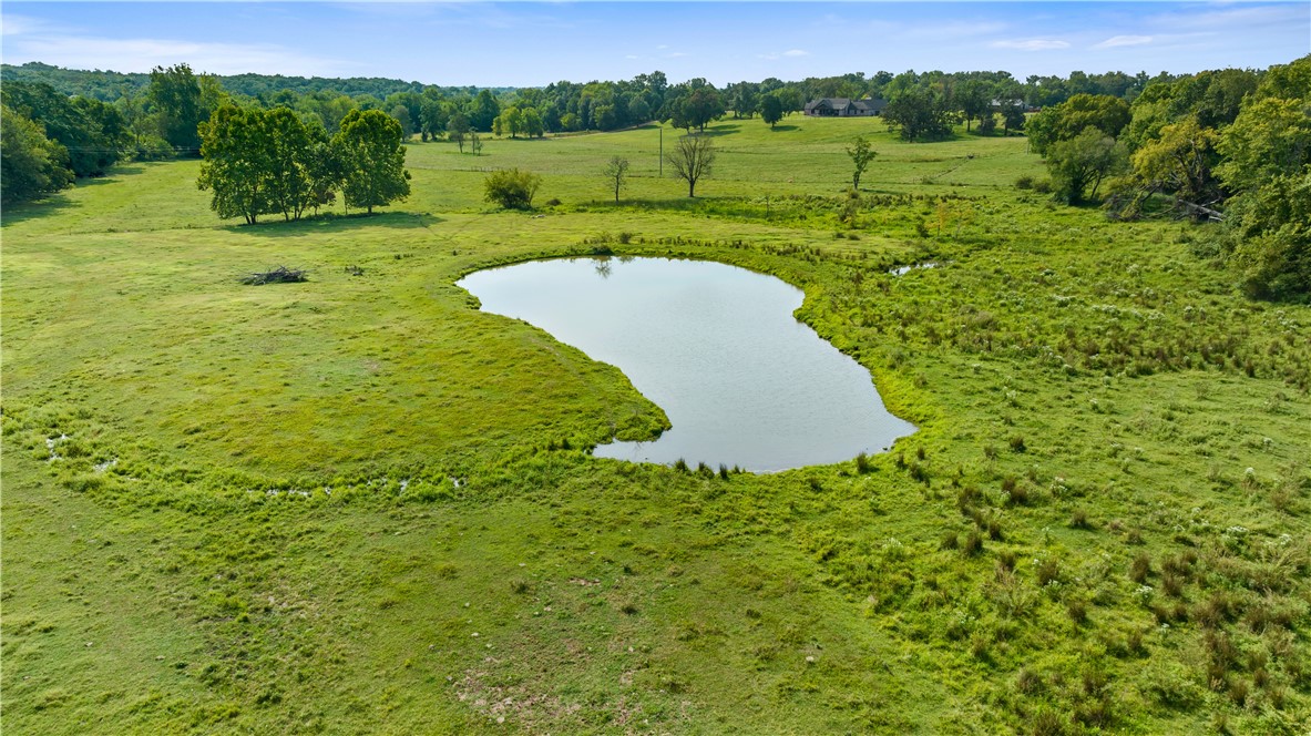 Beautiful flat land in the highly sought after Highfill area. Surrounded by large parcels and estates, this property would make a beautiful estate itself with the huge spring fed pond. It could also be split in to smaller parcels for development. Currently being used for cattle but has sewer, water, and electric access.