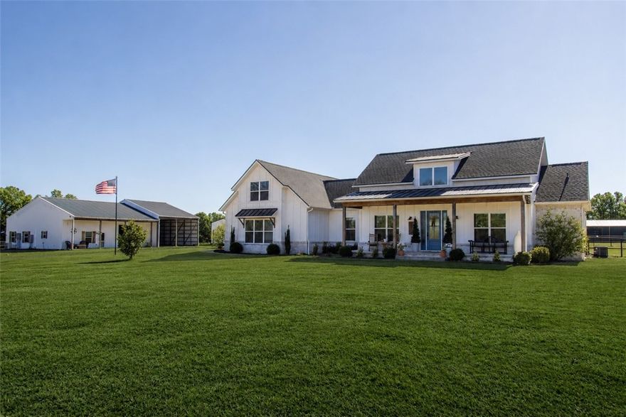 Drive through the gated entrance to this fully fenced farmhouse estate set on 5+ acres. A welcoming front porch opens into a light-filled interior where vaulted ceilings with wood beams frame a spacious living area overlooking fenced pasture and backyard. The chef’s kitchen features quartz countertops, abundant cabinetry, and an oversized walk-in pantry. Outdoor living shines on the covered back patio with built-in grill. The primary suite offers a spa-like bath, expansive walk-in closet, and double-entry utility access. Two additional bedrooms include walk-in closets, and an office is being used as a formal dining room. Zero thresholds and wide doorways provide ADA-compliant accessibility, and a whole-house  back up generator adds peace of mind. Equestrian amenities include 2 stalls with freeze-proof waterers, tack room, and wash rack. The 1,440 sq ft in-law suite features a kitchen, living, bed/bath, mini-splits, and oversized garage with RV parking and hookups. The best of country living just minutes from town!