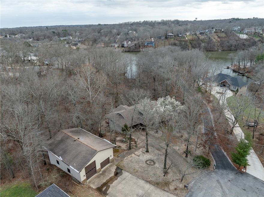 Exceptional 1408 sq ft detached workshop, perfect for storing your recreational vehicles or workshop! Situated on a double .84 acre lot, the main floor features; open Dining / Living Room, spacious eat-in Kitchen, stunning winter lake views, wood burning fireplace in Living Room, and Primary suite w/ private Bathroom & walk in closet. Spacious 2nd and 3rd Bedroom. Efficient Kitchen w/ pantry. Three seasons room complete with wood stove. Walk out basement features; Family Room w/ wood burning fireplace, 4th Bedroom, and dedicated Office / Video / Music Studio. Additional features; upper deck & lower level patio, and workshop location. 4 Bedroom septic. Bentonville Schools. Easy access to Hwy 71 / I49 for daily commute.