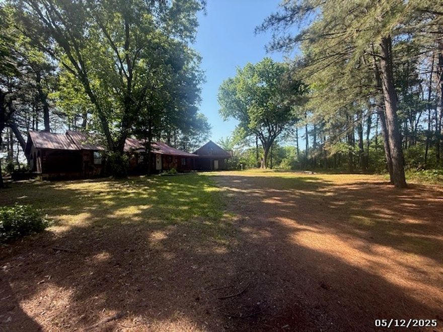 Enjoy the country setting while still being close to town with this 4 bedroom 2 bath home offering a detached bonus room and bath, attached carport, large trees, with 1421 sft(per tax records) sitting on 1.23 acres +/- (per tax records). This home offers beautiful rock work, a metal roof, wood burning fireplace, rear deck, covered front porch, split floor plan, open concept kitchen and living area, and large trees. Realtors see private remarks.