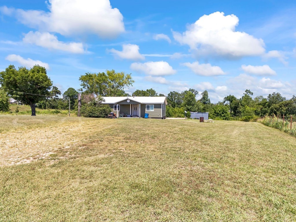 Great opportunity for long term investment while producing rental income. Over five and a half acres across from XNA. Home has newer (3 years) metal roof, and flooring updates. A covered front porch with country views, 10x14 storage building, and room for an RV (with water and electric hookups). Just .3 miles on gravel road right off 264.