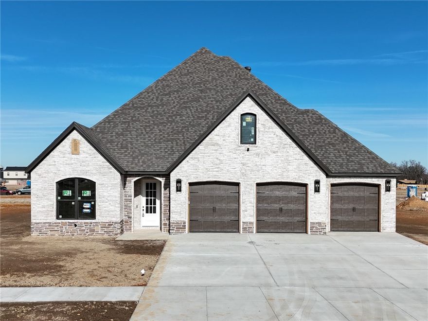 Welcome to County Line Square, a new Springdale community steps from Shaw Family Park with a pool and pavilion for residents. The entry opens to a guest bedroom or office and a full bathroom on the left, giving you flexible space for visitors or work. The hallway leads into an open living and dining area with a stone fireplace as the focal point and engineered wood floors throughout the first floor. The kitchen connects to the living space and includes a large island, 3CM granite countertops, cabinets to the ceiling, GE Profile stainless steel appliances, and a pantry. The main level primary suite features a vaulted ceiling and a bathroom with a double vanity and centered makeup vanity, a walk-in shower, and a large walk-in closet that connects to the laundry room. Upstairs offers 2 bedrooms and a full bathroom. Enjoy the covered back patio and a spacious 3-car garage. A fence, gutters, and blinds are included. Builder’s preferred lender is offering $3500 toward closing costs or a rate buy down. *Agent Owned*