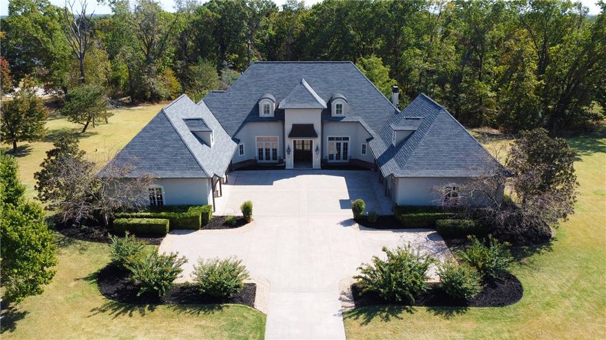 Welcome to Talamore, one of the most highly sought-out subdivisions in Northwest Arkansas. This custom-built builder-owned European estate features grand architecture and exudes a cozy, yet formal atmosphere. The home spans 6,969 SF (4 bedrooms, 4 bathrooms) with a 6-car garage nestled on 3.63 lush acres complete with an in-ground saltwater pool. Detached 1,015 SF guest house (1 bedroom, 1 bathroom) equipped with brand new S/S appliances. Owner’s primary suite is luxurious and features a sitting area overlooking the pool. Kitchen is a chef’s dream and includes a separate wet bar. This masterpiece is an entertainer’s delight featuring multiple indoor and outdoor entertainment areas. Special rooms include executive office, library, formal dining room, living room, bonus room with wet bar, exercise room, and a 510 sf workshop. Upgrades galore. This is your chance to experience privacy and luxury living at it’s finest.
